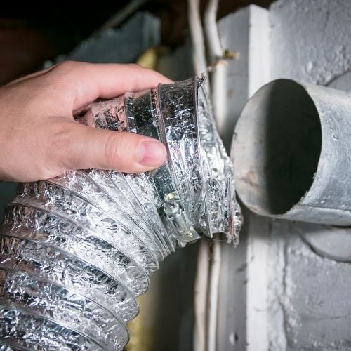 Crushed dryer vent hose behind the unit -Niceleys Appliance Repair Heating and Cooling